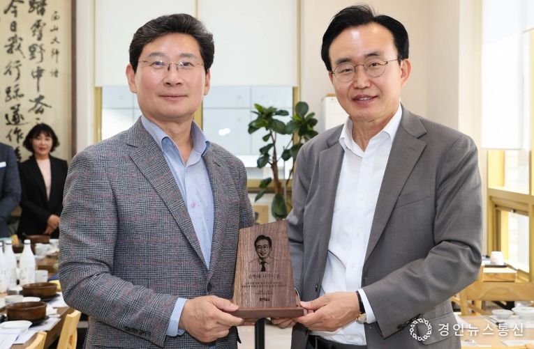 25일 이상일 용인특례시장(왼쪽)이 윤병태 나주시장에게 목재 기념패를 전달하고 있다.