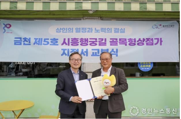 유성훈 금천구청장(왼쪽)과 김명식 상인회장이 골목형상점가 지정서 교부식을 진행하고 기념촬영을 하고 있다